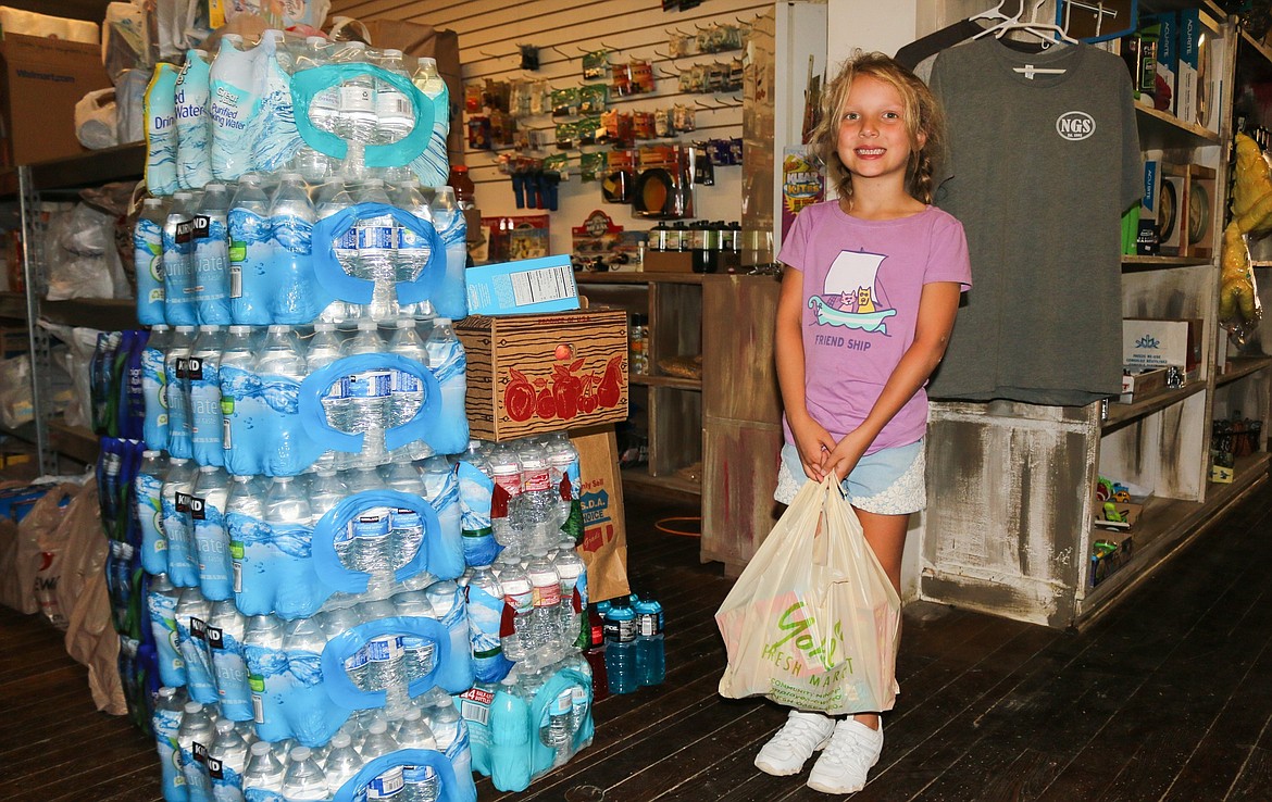 Photo by Mandi Bateman
Claire Presta, 5, helps her mother bring donations to the Naples General Store, that will go on to Montana.