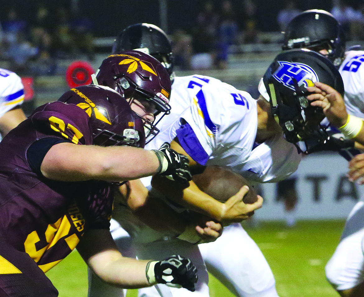 Connor Vanderweyst/Columbia Basin Herald
Moses Lake defenders Hunter Cruz (middle) and Carson Evans (97) put a hit on Hanford quarterback Garrett Horner.