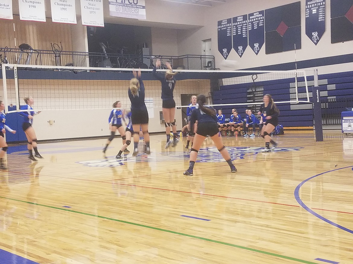 The varsity team leaps high to block the ball during its match against Clark Fork.