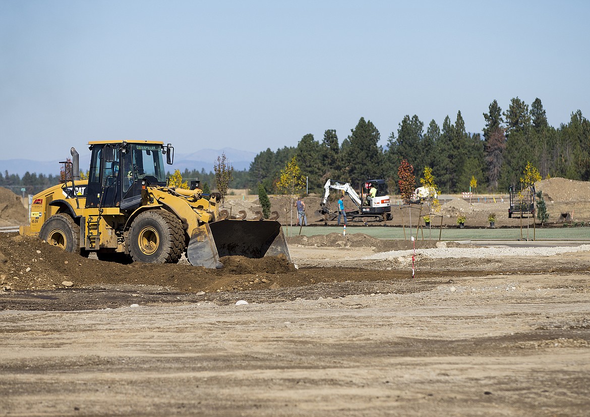 LOREN BENOIT/PressA tractor levels piles of dirt while crews work on landscaping Thursday afternoon at the Hayden North development site off of Lancaster.