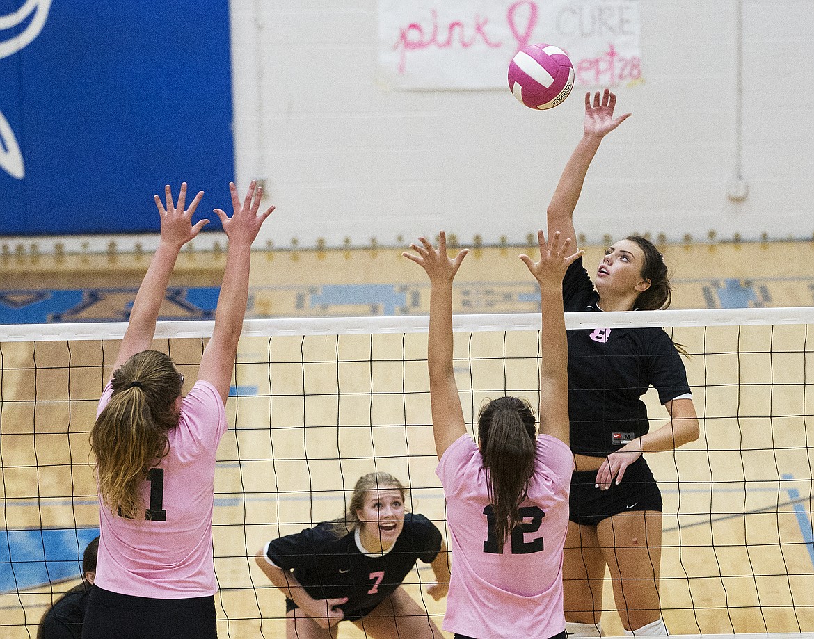 LOREN BENOIT/Press

Post Falls senior Allison Munday spikes the ball by Coeur d&#146;Alene defenders Elizabeth Schraeder (11) and Taylin Rowley.