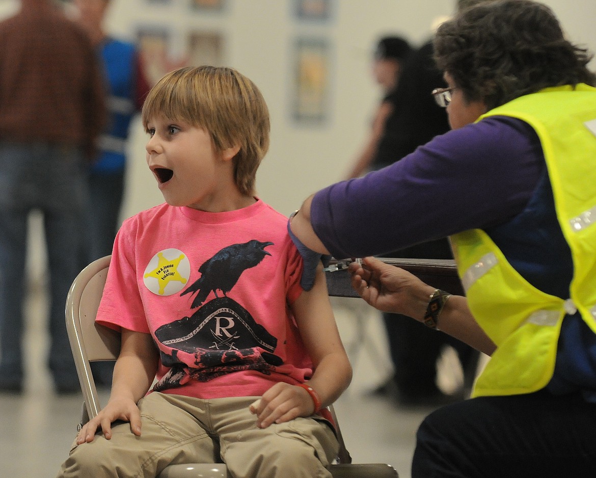 Taite Hammer, 8, is surprised as he gets a shot from Maria Arrington  at the Flathead City-County Health Department&#146;s Flu Clinic at the Flathead County Fairgrounds on Tuesday. (Aaric Bryan/Daily Inter Lake)