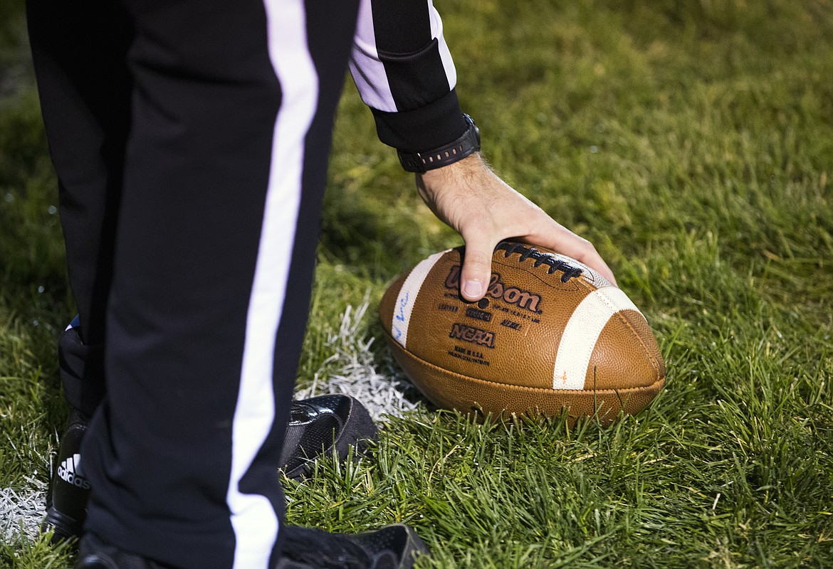 LOREN BENOIT/Press
A referee picks up a football after a play.