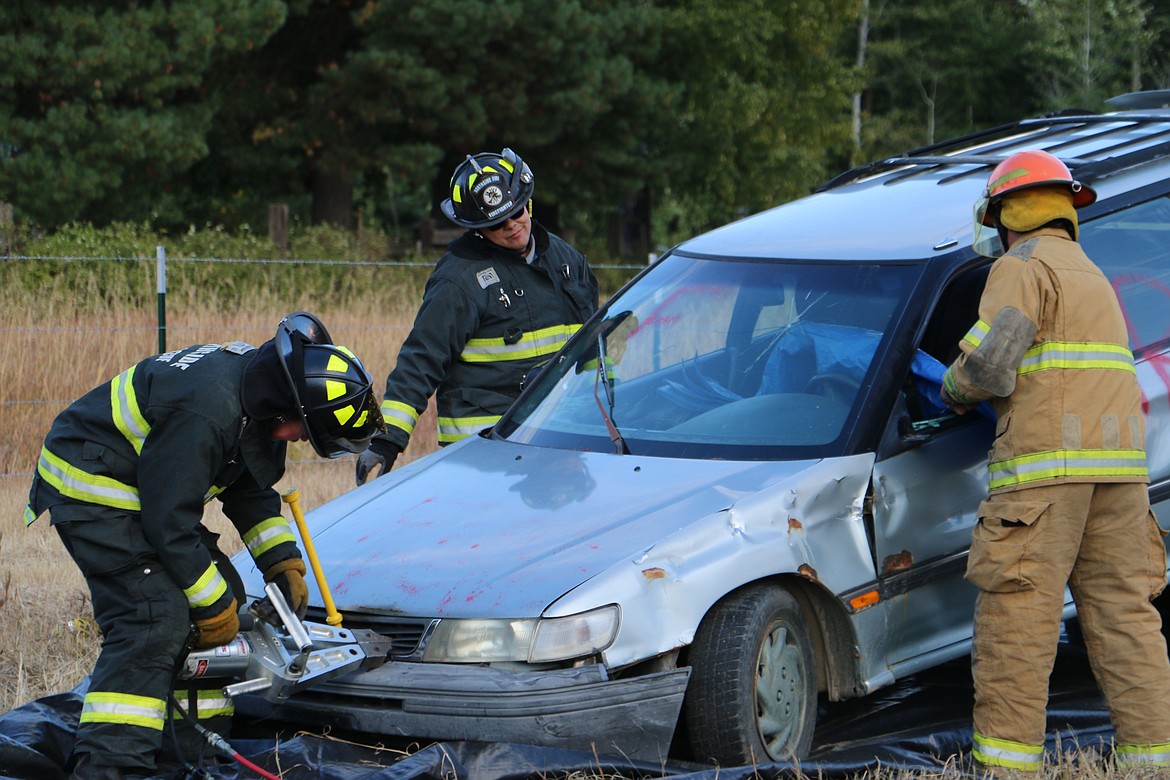 (Photo by MARY MALONE)
The Northside Fire District demonstrated a forced entry technique used in vehicle crashes for a crowd of community members during Ponderay Neighbor Day Saturday.