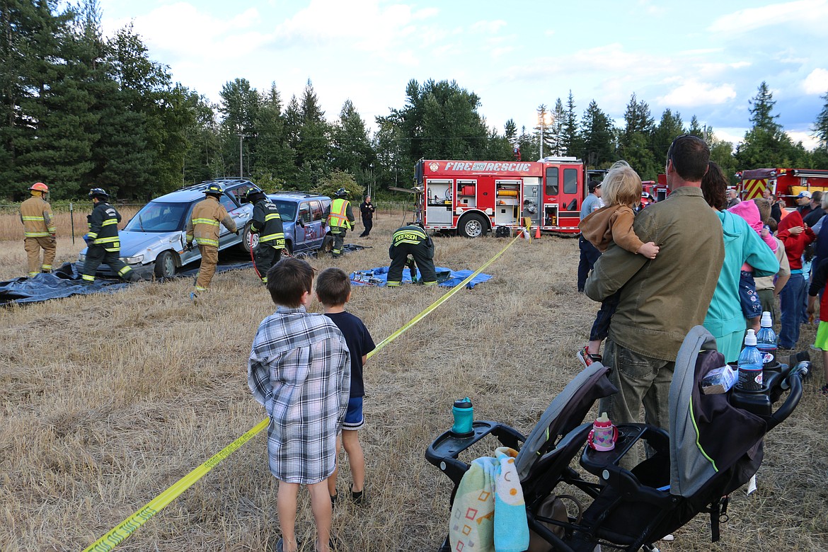 (Photo by MARY MALONE)
The Northside Fire District demonstrated a forced entry technique used in vehicle crashes for a crowd of community members during Ponderay Neighbor Day Saturday.