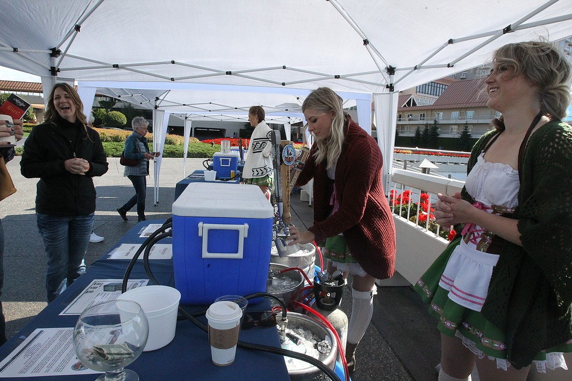 DEVIN HEILMAN/Press
Shara Schorzman fills a mug with a bubbly brew Saturday as Tracey Newton, left, of St. Maries and Schorzman&#146;s fellow beer maiden Emma Raynor share a laugh on the front walkway of The Coeur d&#146;Alene Resort. The Oktoberfest tents, filled with a variety of beers to try and traditional German fare to feast upon, welcomed guests to hang out and enjoy the German celebration.