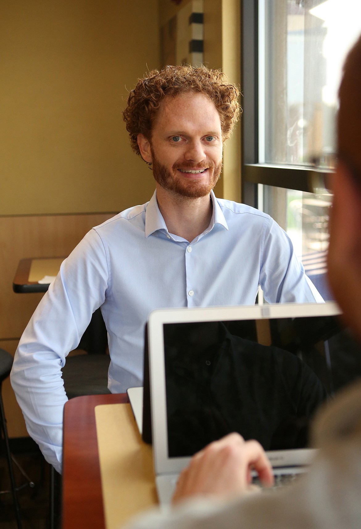 Neuroscientist Braxton Norwood pauses for a photo while he and colleauge, David Booth, fill out grant applications for epilepsy research funding at City Brew Coffee in Kalispell. (Mackenzie Reiss/Daily Inter Lake)