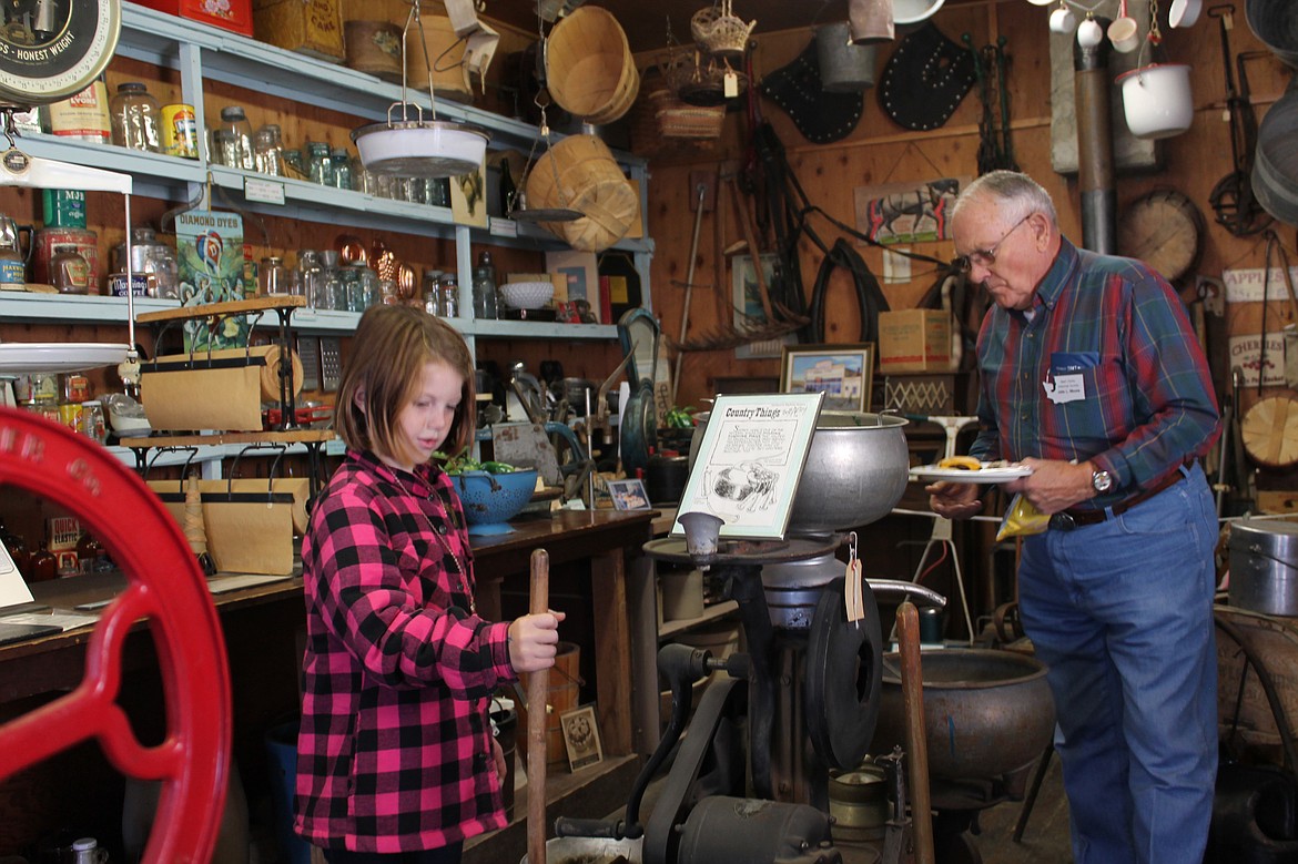 Joel Martin/Columbia Basin Herald
Eight-year-old Natasha Nelson gets the feel of a butter churn in the general store at the Grant County Museum&#146;s Pioneer Day Saturday.