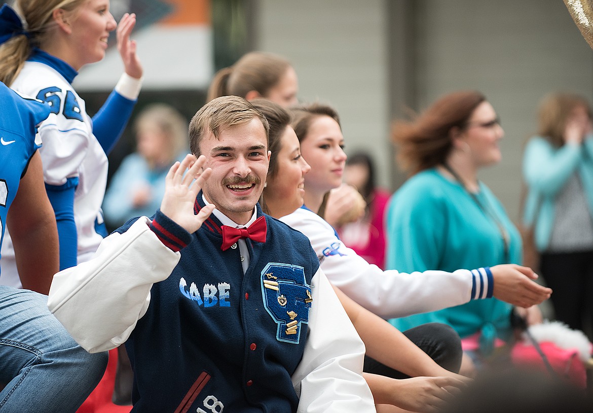 Sporting a red bowtie, senior Gabe Knudsen waves to the crowd during the Columbia Falls High School Homecoming parade Monday. It was the first time the parade has been held since 1984.