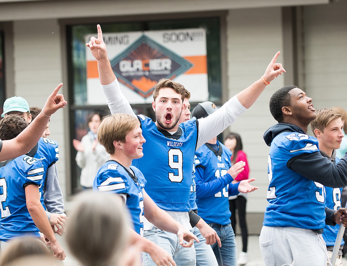 Senior Logan Kolodejchuk gestures to the crowd during the Homecoming parade Monday.