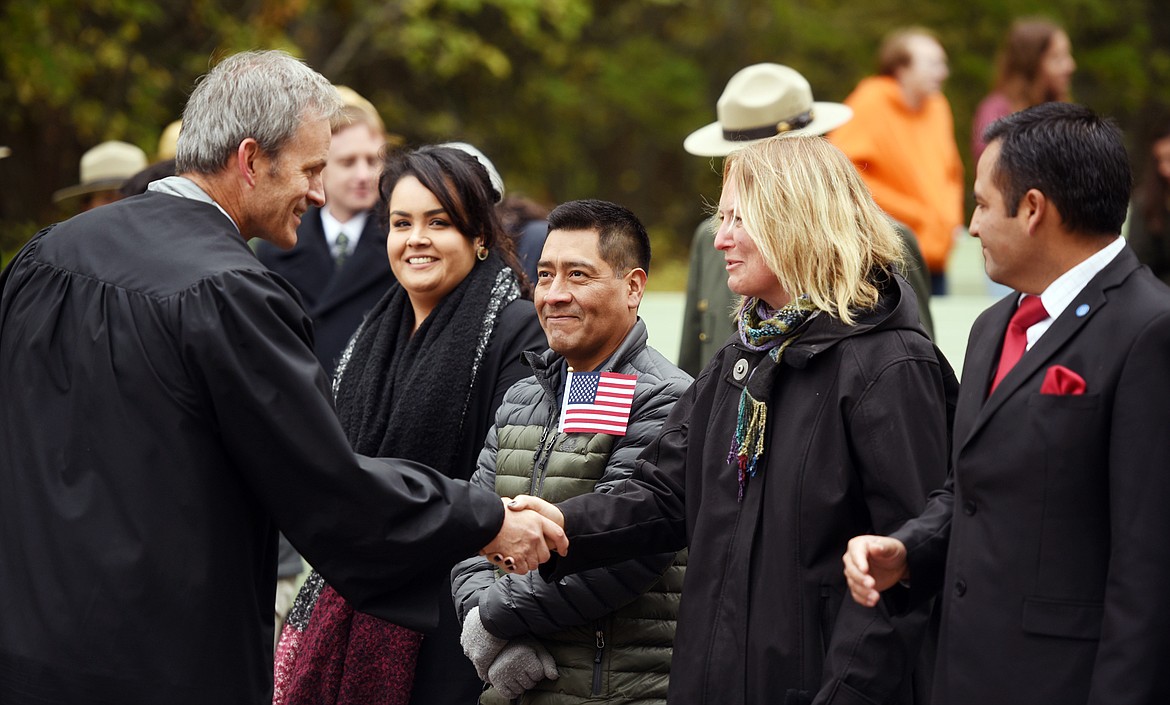 The Honorable Brian Morris, U.S. District Judge in Montana, shakes hands with Elin Charlotta Hibbs of Sweden following the naturalization ceremony on Friday.  Beside her to the left are fellow new citizens Rigoberto Garate Salas and Briza Karina Galvan Talamantes, both of Mexico, and Rodrigo Antonio Jofre Diaz of Chile.