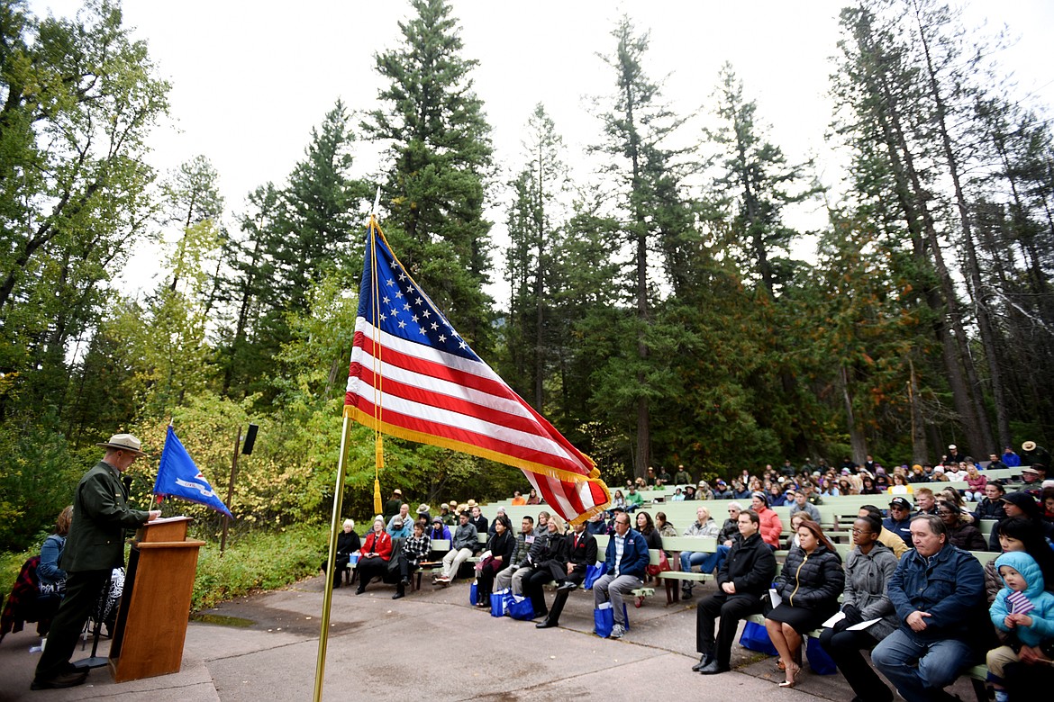 The American flag flies at a naturalization ceremony in Glacier National Park on Friday. Guest speaker Eric Smith, deputy superintendent of Glacier Park, makes his remarks.