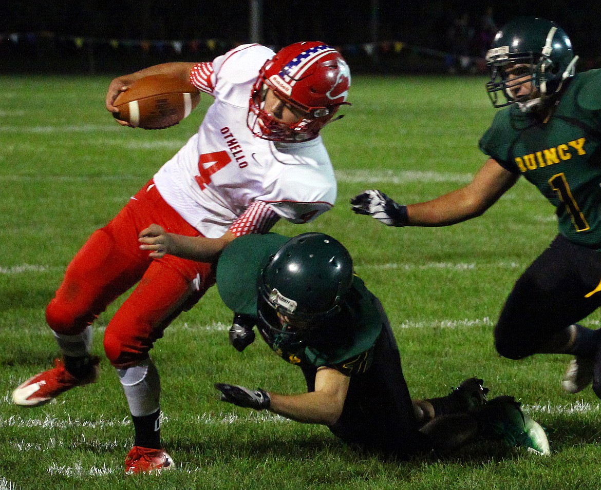 Rodney Harwood/Columbia Basin HeraldOthello running back Isaac Barragan (4) gets to the edge against Quincy defenders during the first quarter of Friday's CWAC North opener at Jaycee Stadium.