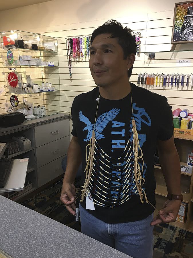 Patrick Matt, Jr. dons a breast plate made of buffalo bone and buckskin hide at The People’s Center. Matt attended a workshop to learn how to market his products.