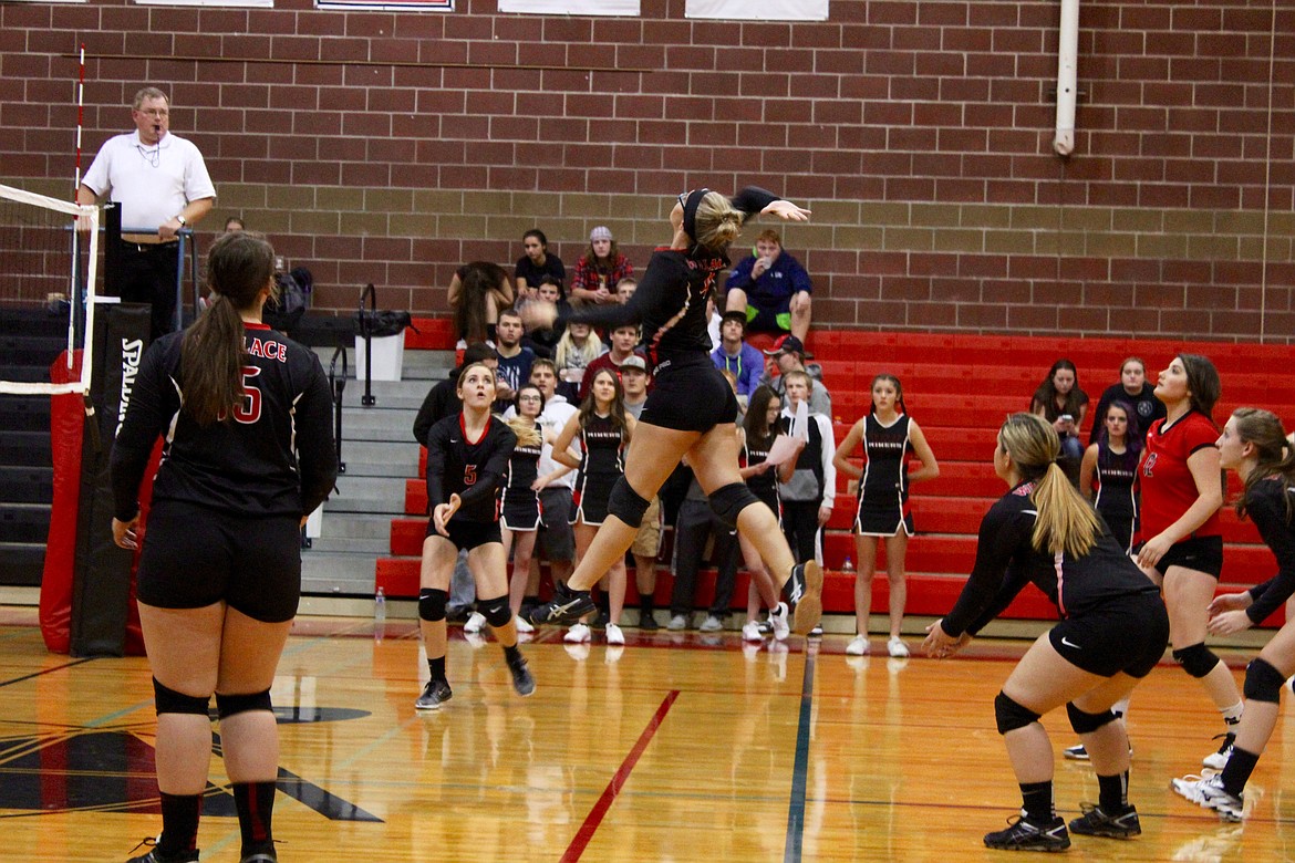 Fellow Lady Miners watch as Halei Ungerbuehler jump to spike the ball.