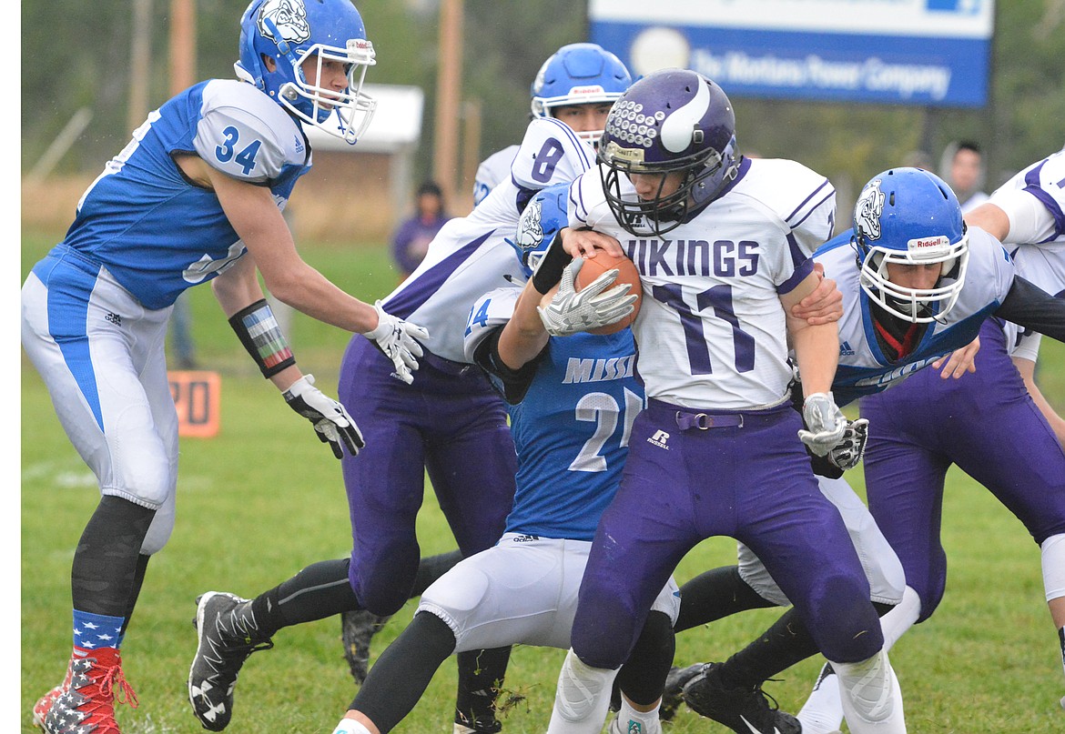 MISSION TACKLERS Layne Spidel (34) and Wacey McClure attempt to tackle Charlo ball carrier  Garrett Vaughan in a earlier contest this season. With a victory against Arlee this Friday night at Mission High School the Bulldogs can qualify for the Class C, 8-man playoffs. (Jason Blasco/Lake County Leader)