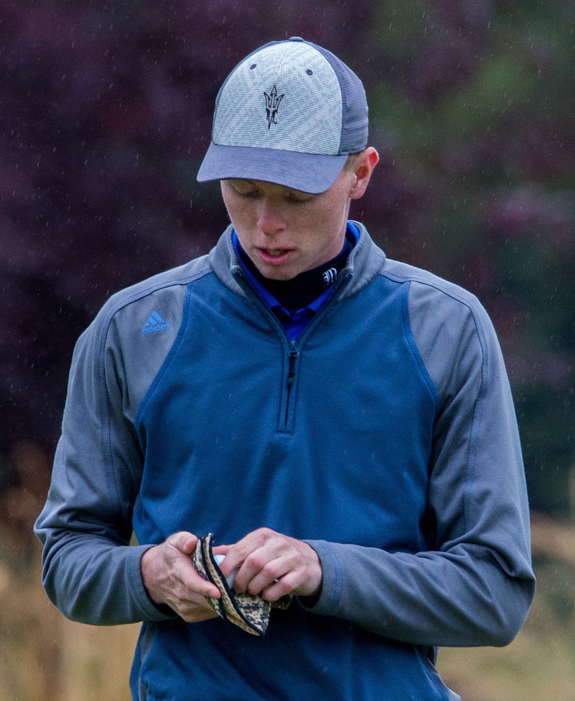 Libby's Ryggs Johnston dries off a golf ball during invitational play at Cabinet Peaks Golf Course on Tuesday. See story on page B2. (John Blodgett/The Western News)