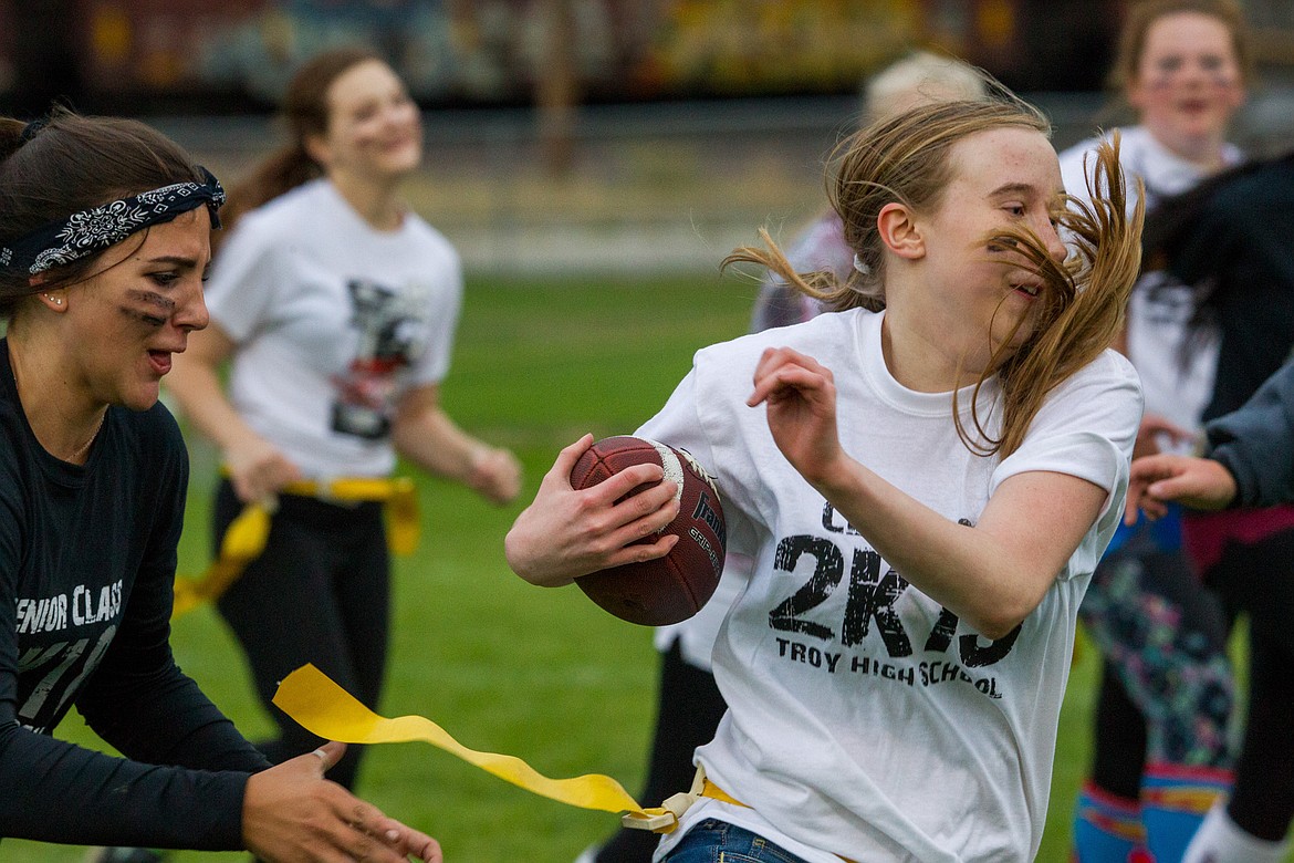 Bottom left: Aurora Becquart, left, reaches for Sarah Shadden&#146;s flag during a game of flag football Wedneday night at a Troy High School homecoming event. (John Blodgett/The Western News)