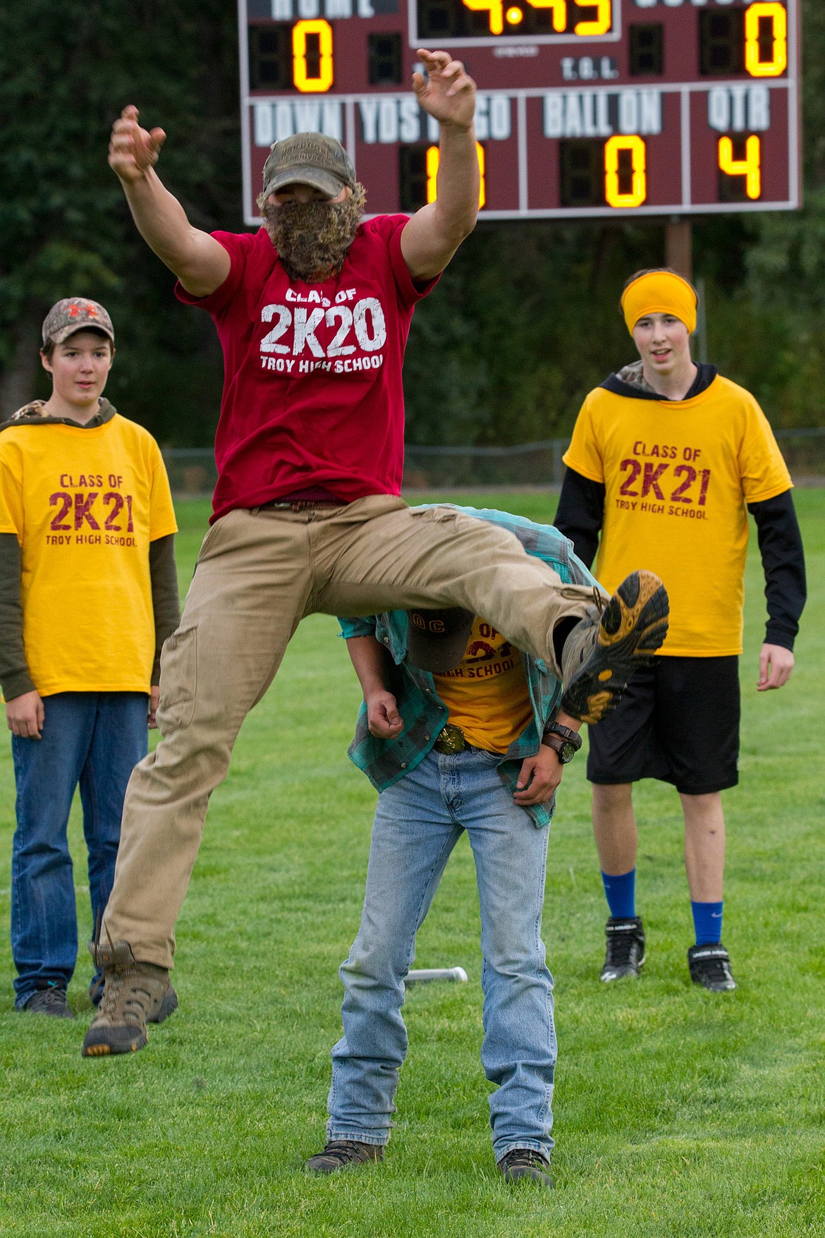 Alex Harper jumps over Gus Schrader as Collin Stecher, left, and Malachi Montgomergy watch during Troy High School homecoming festivities Wednesday evening. (John Blodgett/The Western News)