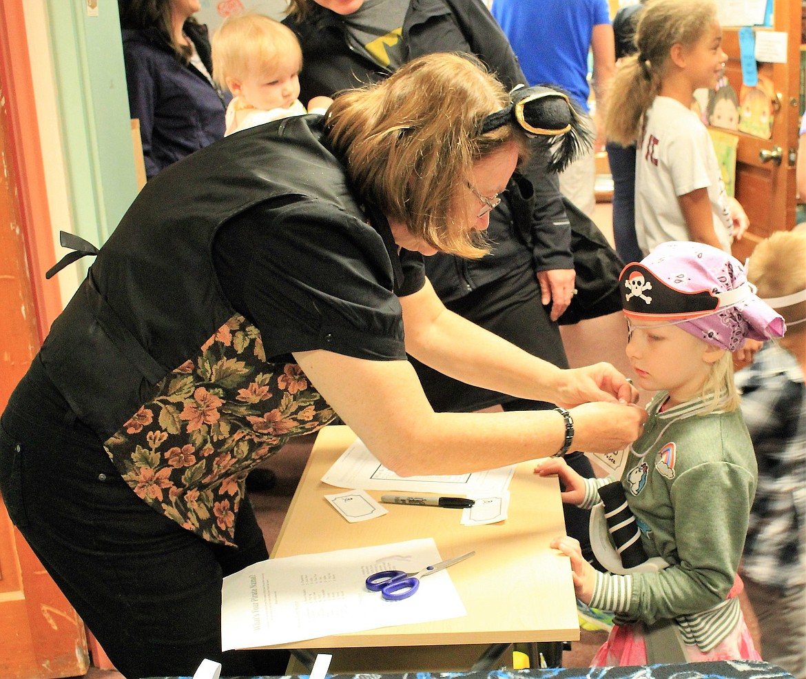 Library Director Guna Chaberek (Money Buckets Stinksalot) fashions a name for a young student as she joins the fun at the Talk Like a Pirate Day in Superior. (Kathleen Woodford/Mineral Independent)