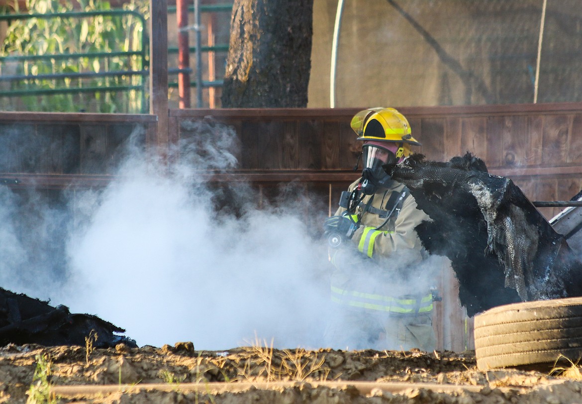 Photo by Mandi Bateman
Firefighter battles the smoke with the remains of the burned boat.