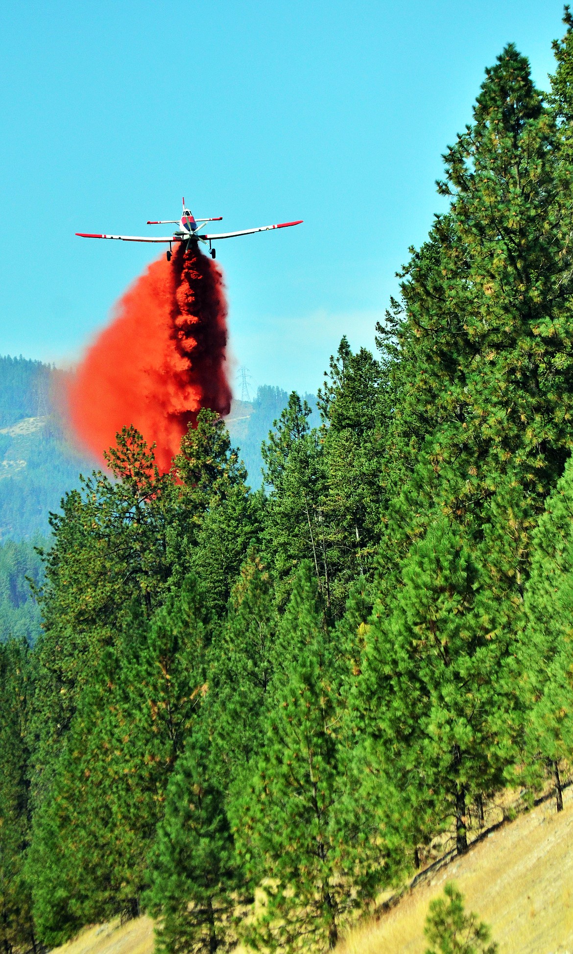 One of two fixed airplanes dropping retardant over one of the fires on Highway 135. (Erin Jusseaume/ Clark Fork Valley Press)