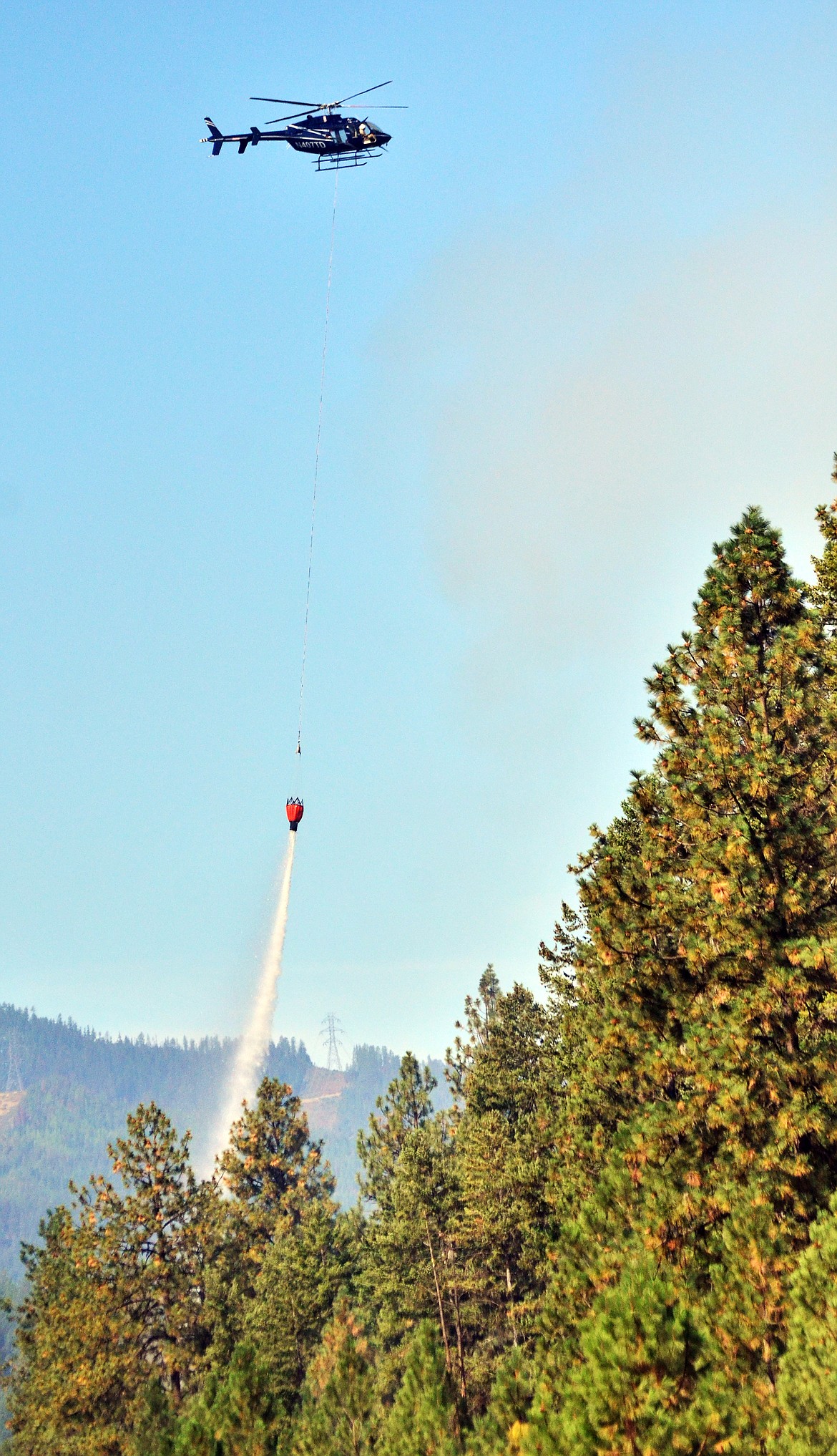 Pilots doing what they can to reduce the smoke and intensity of the flames over one of the fires on Highway 135. (Erin Jusseaume/ Clark Fork Valley Press)