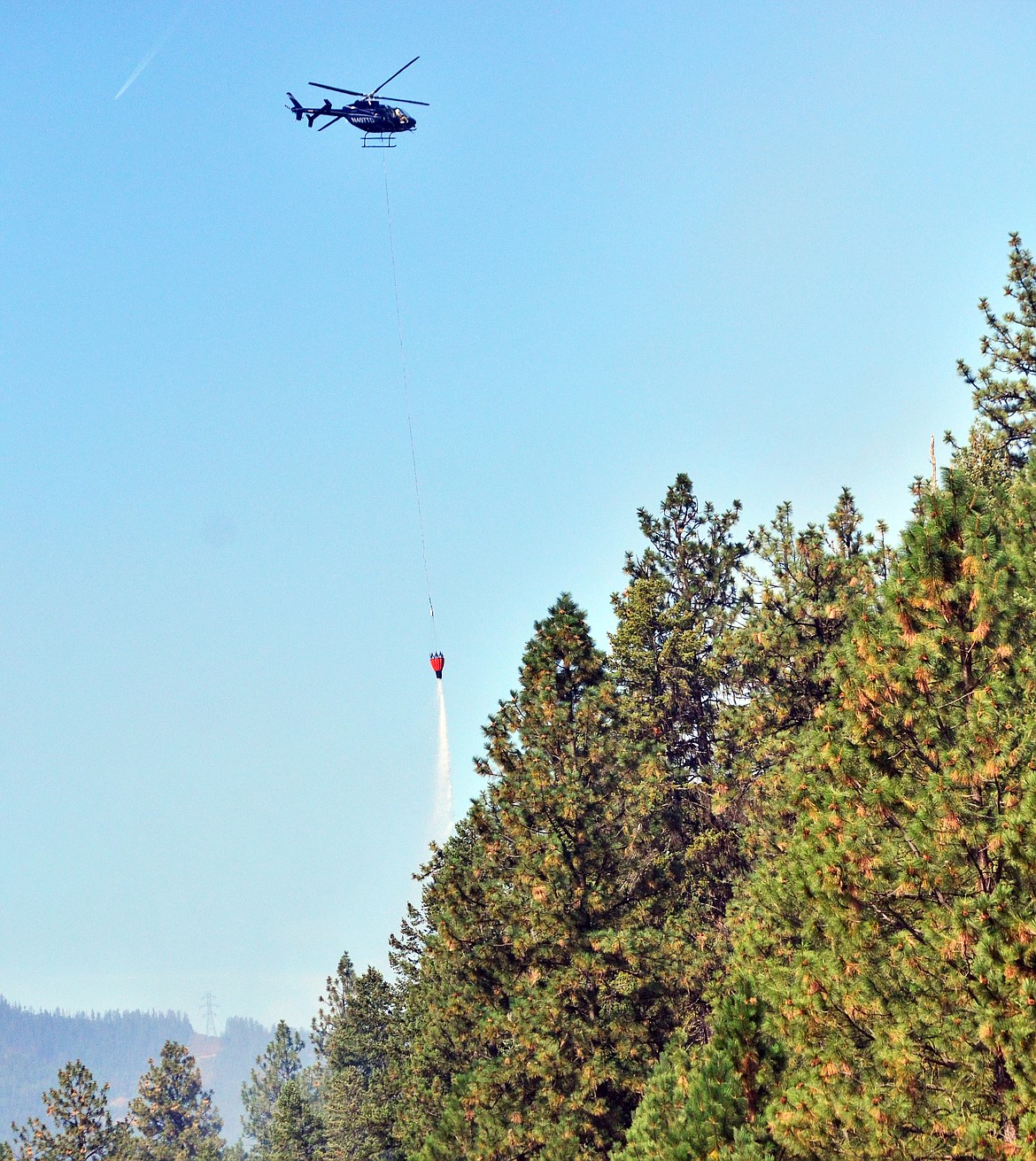Perfect precision to drop water from the bucket by the pilot on Highway 135. (Erin Jusseaume/ Clark Fork Valley Press)