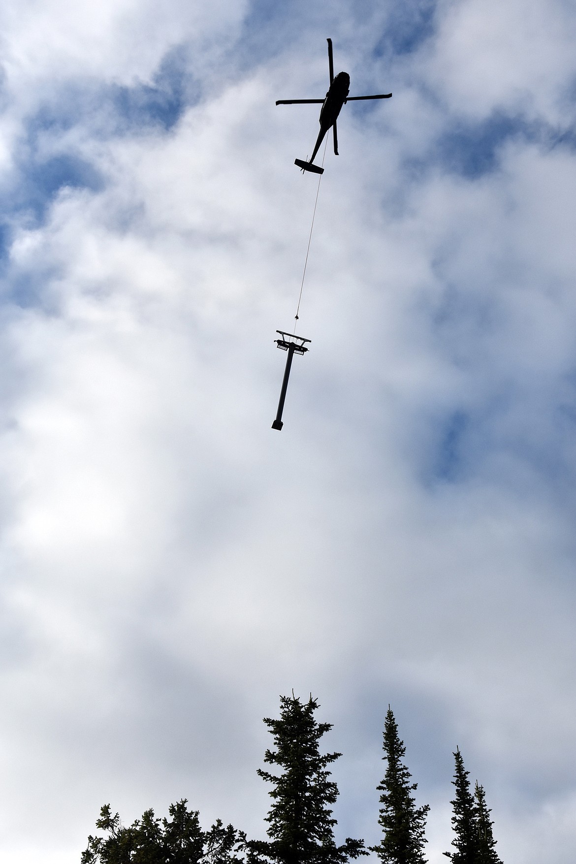 A helicopter flies a chairlift tower Sunday morning to the East Rim at Whitefish Mountain Resort. Chair 5 is being relocated from Ptarmigan Bowl to the East Rim as part of  a $1.2 million project aimed at improving skier access in the area. (Heidi Desch/Whitefish Pilot)