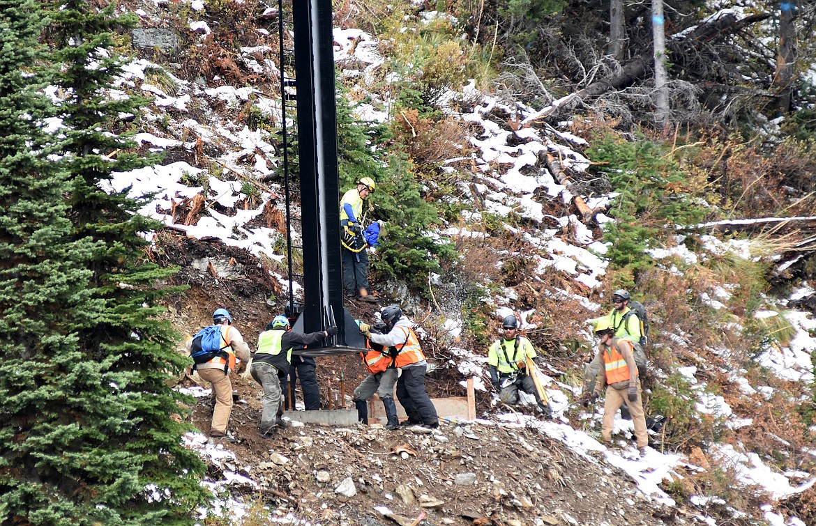 The crew guides one of the chairlift towers into palce as its delivered by helicopter Sunday morning as part of the Chair 5 relocation to the East Rim from Ptarmigan Bowl at Whitefish Mountain Resort. (Heidi Desch/Whitefish Pilot)