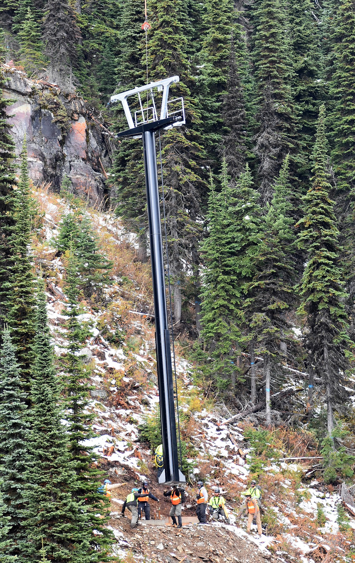 Crews guide one of the chairlift towers as its delivered by helicopter Sunday morning as part of the Chair 5 relocation to the East Rim from Ptarmigan Bowl at Whitefish Mountain Resort. (Heidi Desch/Whitefish Pilot)