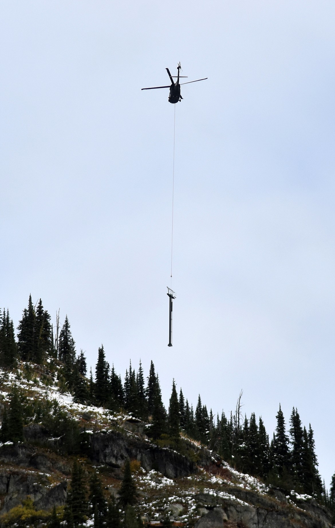 A helicopter flies a chairlift tower Sunday morning to the East Rim at Whitefish Mountain Resort. Chair 5 is being relocated from Ptarmigan Bowl to the East Rim as part of  a $1.2 million project aimed at improving skier access in the area. (Heidi Desch/Whitefish Pilot)