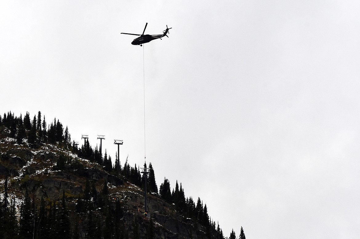 A helicopter flies a chairlift tower Sunday morning to the East Rim at Whitefish Mountain Resort. Chair 5 is being relocated from Ptarmigan Bowl to the East Rim as part of  a $1.2 million project aimed at improving skier access in the area. (Heidi Desch/Whitefish Pilot)