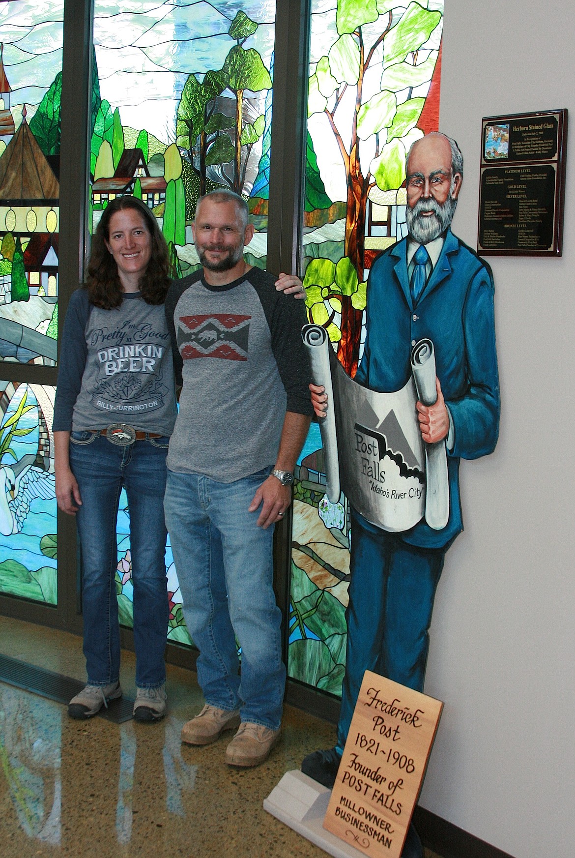 BRIAN WALKER/Press
Monte Martin, the great great grandson of Post Falls founder Frederick Post, and his wife Marisol pose by at statue of Post at City Hall on Friday. They are in front of a stained glass window by local artist Kathy Pierce of Herborn, Germany, which is Post's birthplace and Post Falls' associate city.