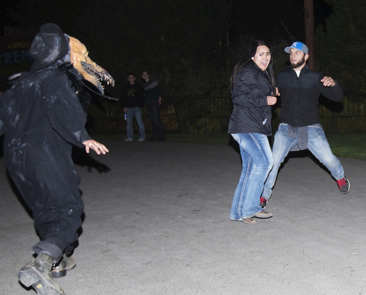 LOREN BENOIT/PressA scarywood actor jumps out a bush to scare Adam Roberts and Tori Renata during opening night of Scarywood.