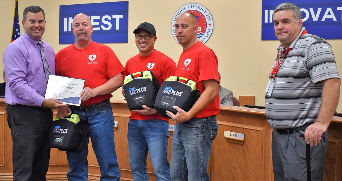 Courtesy photo
The Coeur d'Alene School District's board of trustees thanked Heart Safe on Monday for the nonprofit's donation of automated external defibrillators to be placed in schools. From left are: Casey Morrisroe, school board chairman; Blaine Porter, Coeur d'Alene Fire; Jarrod Pitts, Northern Lakes Fire District; Ryan Asher, Kootenai County Fire and Rescue; and Justin Fine, Coeur d'Alene Public Schools safety and security coordinator.