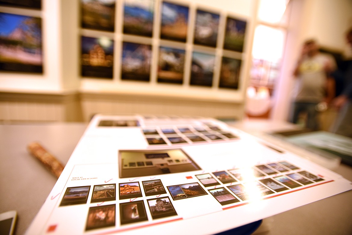 A contact sheet of photographs gets check marked as photos are hung in the Museum of Central School in Kalispell on Thursday, October 5. Terry Abell, Bret Bouda and Executive Director Jacob Thomas were in the process of hanging the show which will open on Wednesday, October 11, with a reception from 5 to 7 p.m.(Brenda Ahearn/Daily Inter Lake)