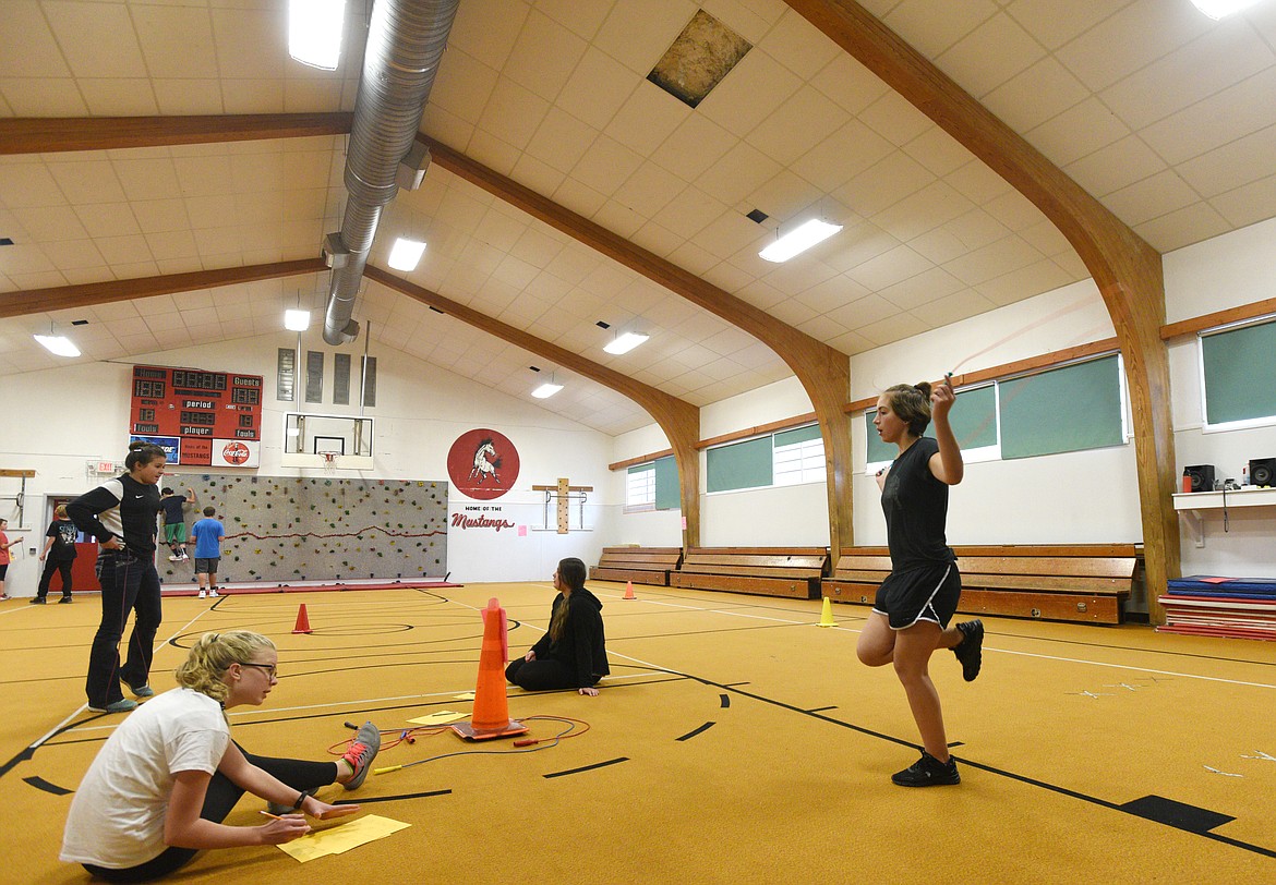 Eighth graders complete a physical fitness test on the carpeted floor of the gym during physical education at Somers Middle School on Thursday. (Aaric Bryan/Daily Inter Lake)