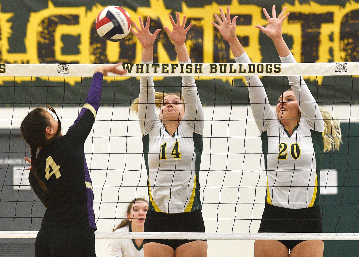 Whitefish seniors Becca Catina (14) and Caily Ross (20) attempt to block a shot from Polson junior Paige Noyes during the Bulldogs win in Whitefish on Tuesday. (Aaric Bryan/Daily Inter Lake)