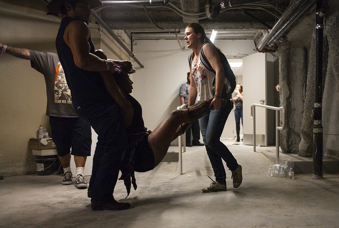 People assist a wounded woman at the Tropicana during an active shooter situation on the Las Vegas Stirp in Las Vegas Sunday, Oct. 1, 2017. Multiple victims were being transported to hospitals after a shooting late Sunday at a music festival on the Las Vegas Strip. (Chase Stevens/Las Vegas Review-Journal via AP)