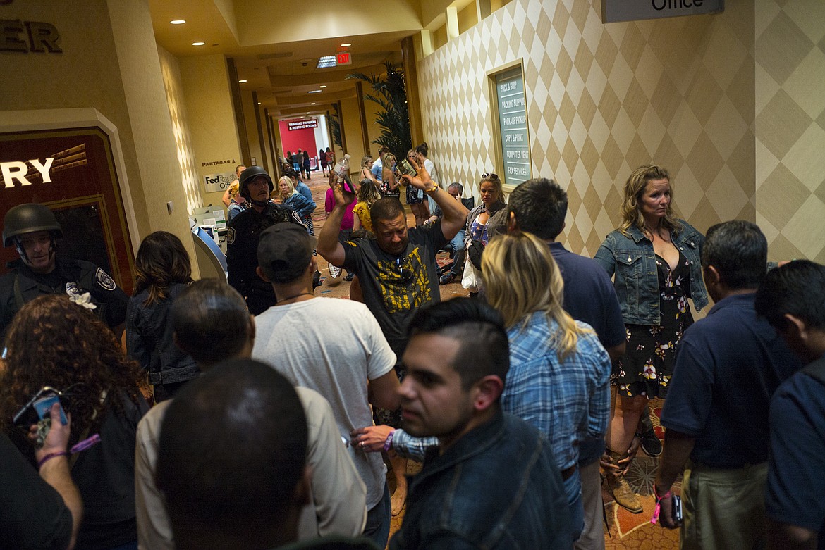 People are searched by Las Vegas police at the Tropicana Las Vegas during an active shooter situation on the Las Vegas Strip on Sunday, Oct. 1, 2017. Multiple victims were being transported to hospitals after a shooting late Sunday at a music festival on the Las Vegas Strip. (Chase Stevens/Las Vegas Review-Journal via AP)