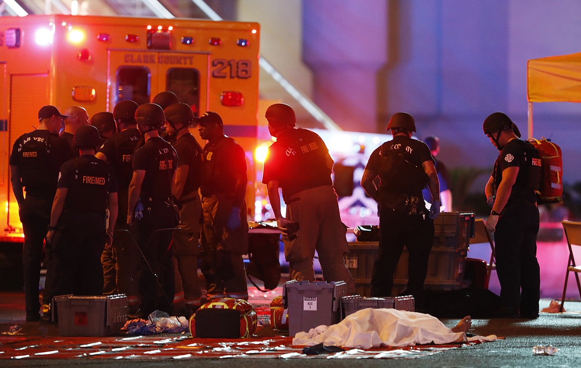 A body is covered with a sheet after a mass shooting in which dozens were killed at a music festival on the Las Vegas Strip on Sunday, Oct. 1, 2017. (Steve Marcus/Las Vegas Sun via AP)