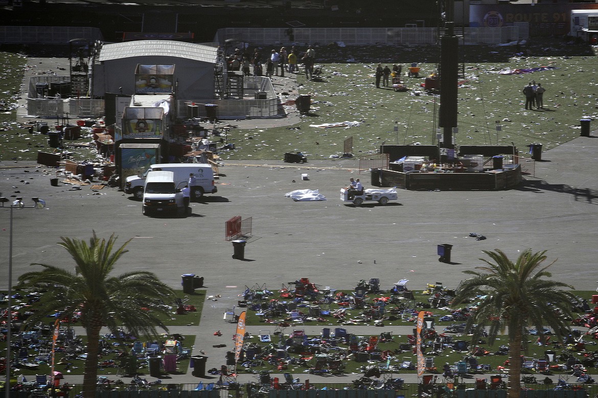 People drive a cart through the scene of a mass shooting at a music festival on the Las Vegas Strip, Monday, Oct. 2, 2017, in Las Vegas. (AP Photo/John Locher)