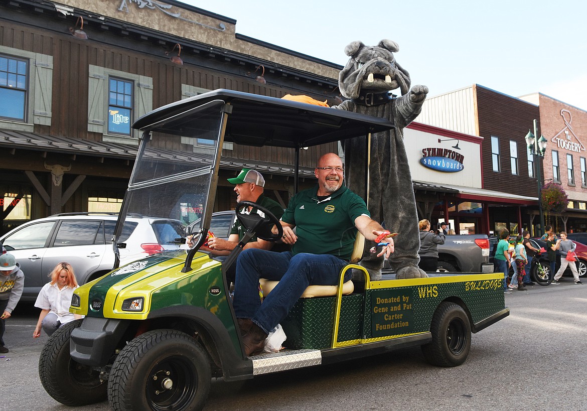 Whitefish High School Assistant Principal Jeff Peck and Principal Kerry Drown toss out candy during the homecoming parade on Friday. (Daniel McKay/Whitefish Pilot)