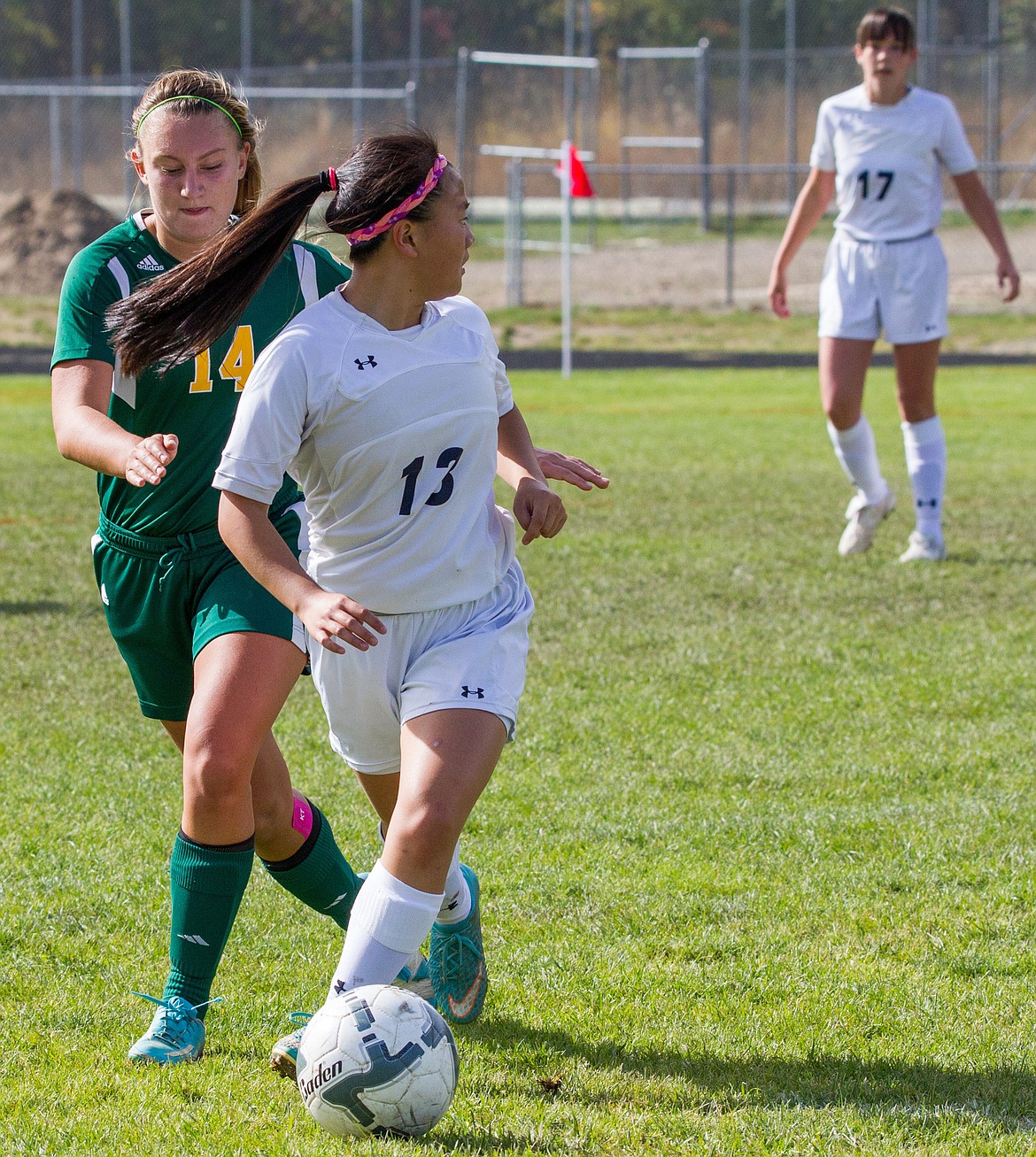 Libby's Sydney Gier, No. 13, looks for an open teammate as Whitefish's Pixie Moore attempts to gain possession of the ball Saturday in Libby. (John Blodgett)