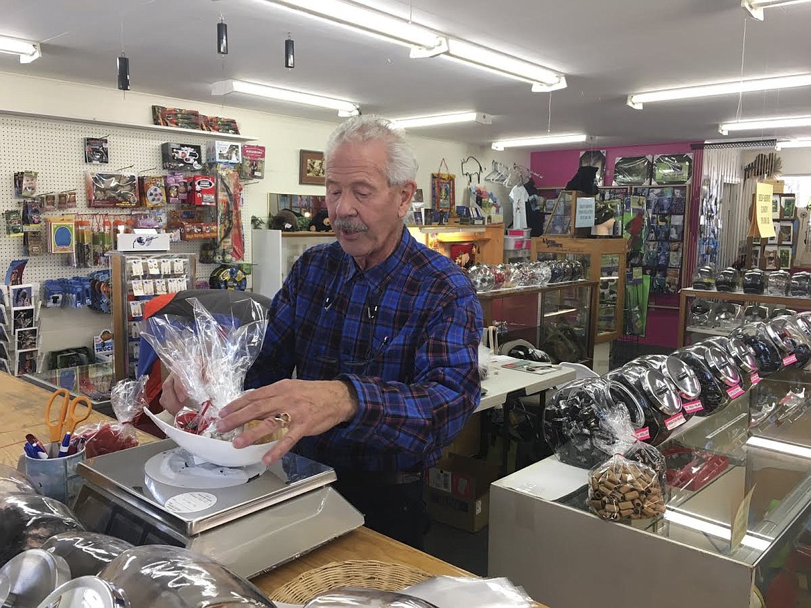 Tony Hoyt, owner of Hummingbird Toys and Treats in Arlee, weighs candies Friday. Hoyt and his wife, Michele, have decided to retire after owning the candy store for three decades. (Ashley Fox/Lake County Leader)