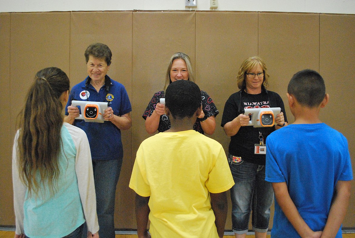 Bob Kirkpatrick/The Sun Tribune - Pictured from left are Lion's Club member Donna Ruttan, Othello School District Director of Health Services RN Abby Hilmes, and Hiawatha's nurse assistant Tiffany Lebacken who are illustrating the eye tests that were conducted with the Plusoptix vision screening device.