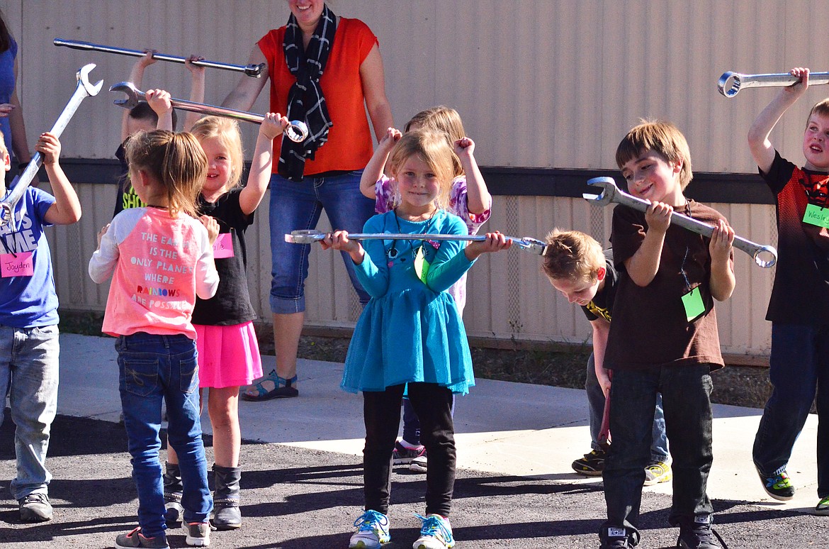 Kyle Burbach from Burbach Mobile Mechanic lets children at Plains School lift some of the tools.