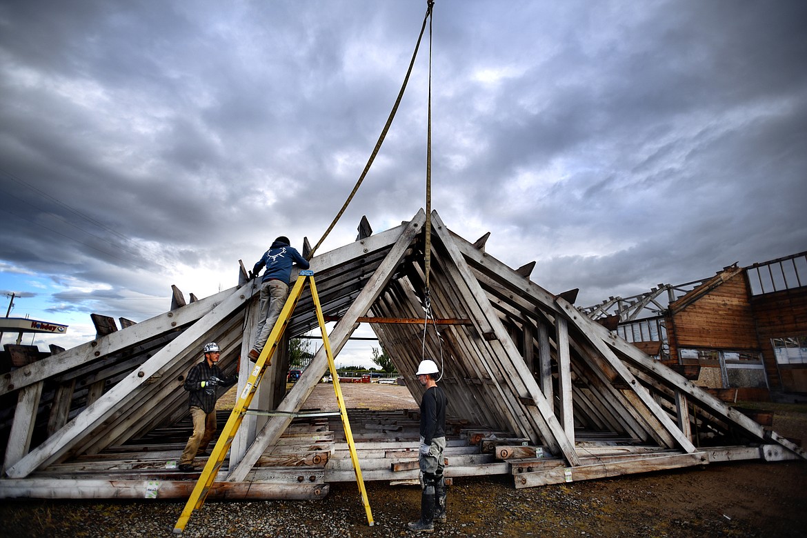 The crew from Heritage Timber LLC works with the rafters of the roof of the Kalispell Lumber Company building on Sept. 20 in Kalispell. The iconic structure is being carefully deconstructed so that, like a giant 3-D jigsaw puzzle, it can be put back together at a new location. (Brenda Ahearn/Daily Inter Lake)