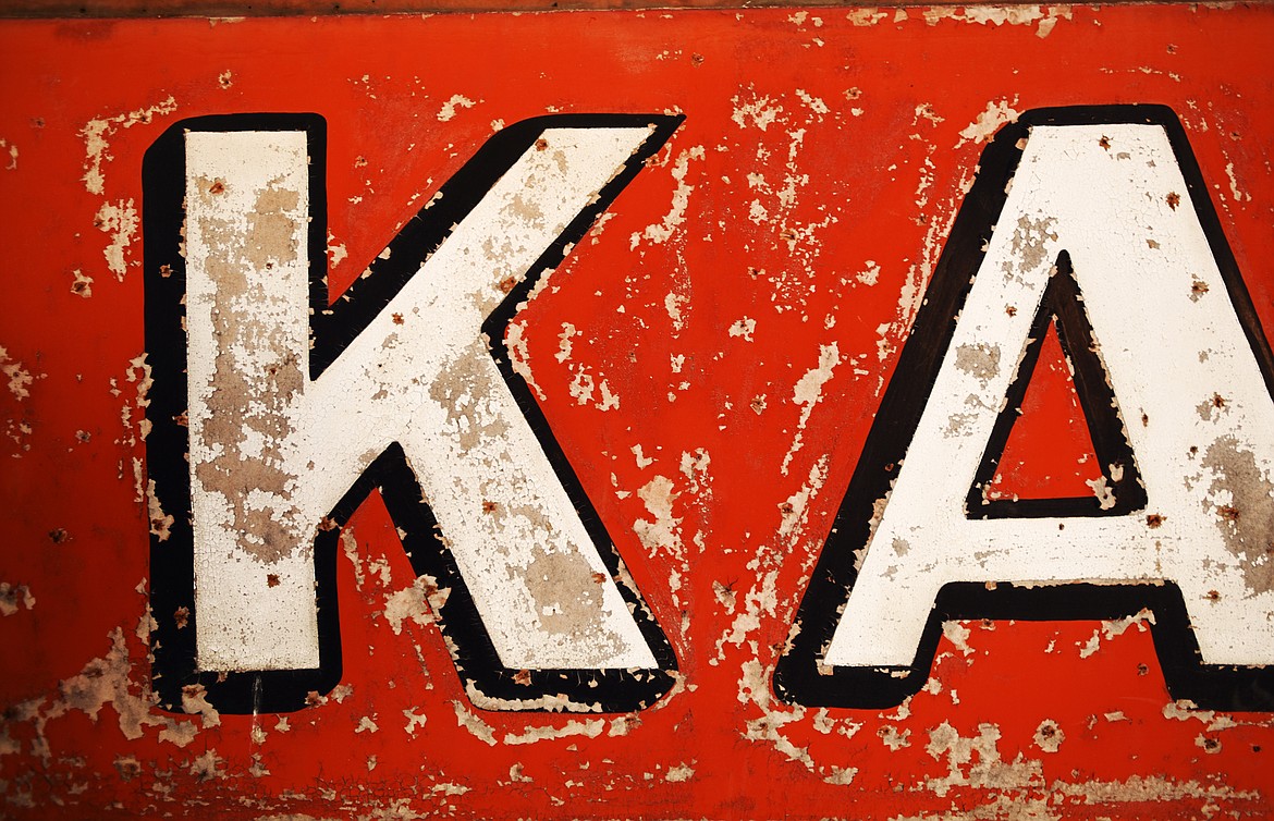 A piece of an old Kalispell Lumber Company sign sits against a wall that will soon be coming down.